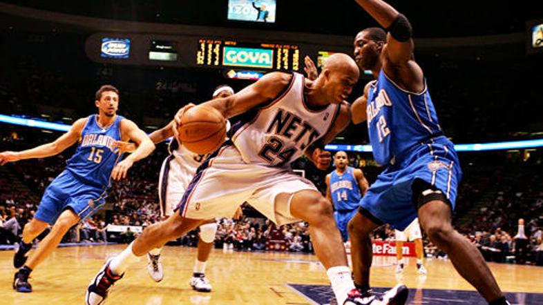 Richard Jefferson (New Jersey) skuša prodreti mimo Dwighta Howarda (Orlando).